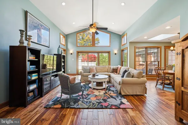 a living room with furniture a wooden floor and large window