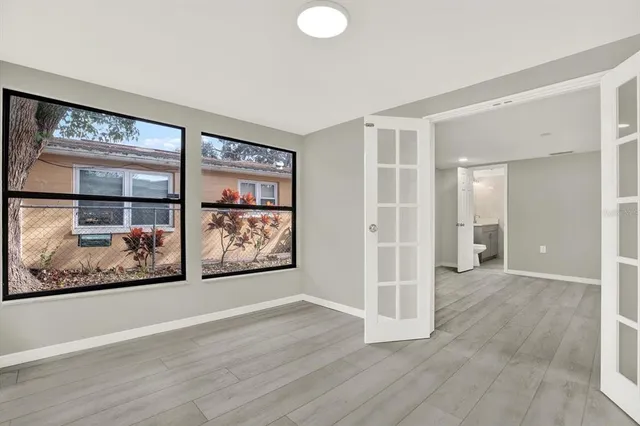 an empty room with wooden floor and painting on the wall