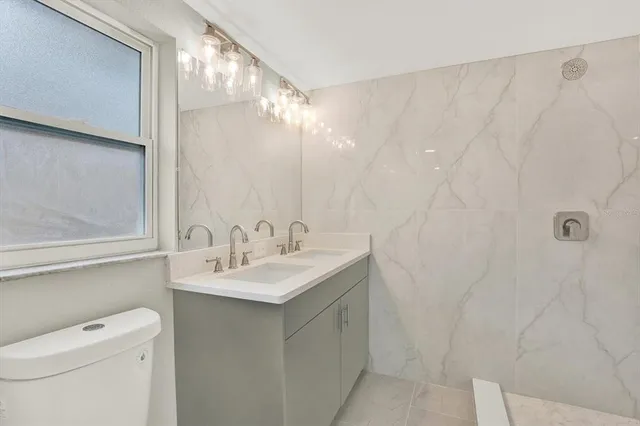 a bathroom with a sink a toilet and a mirror