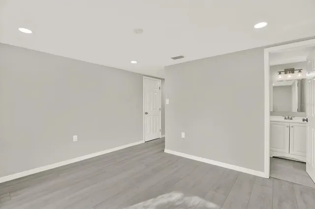 a view of an empty room with wooden floor