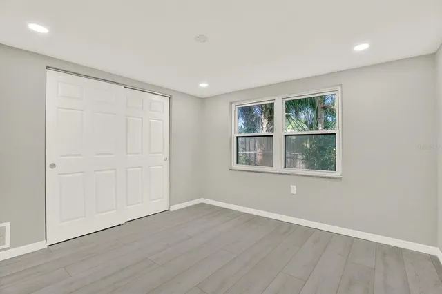 an empty room with windows and closet