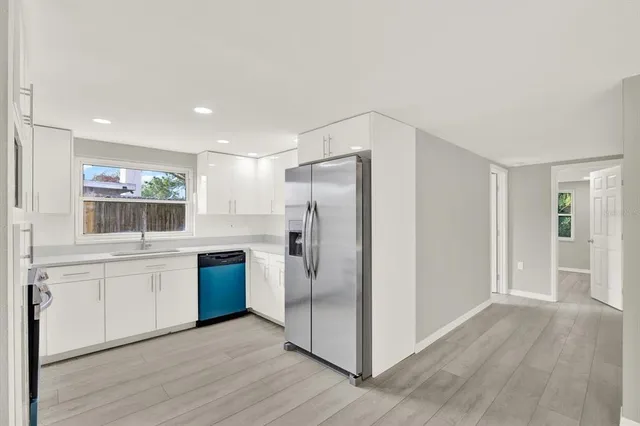 a kitchen with stainless steel appliances granite countertop a refrigerator and a stove top oven