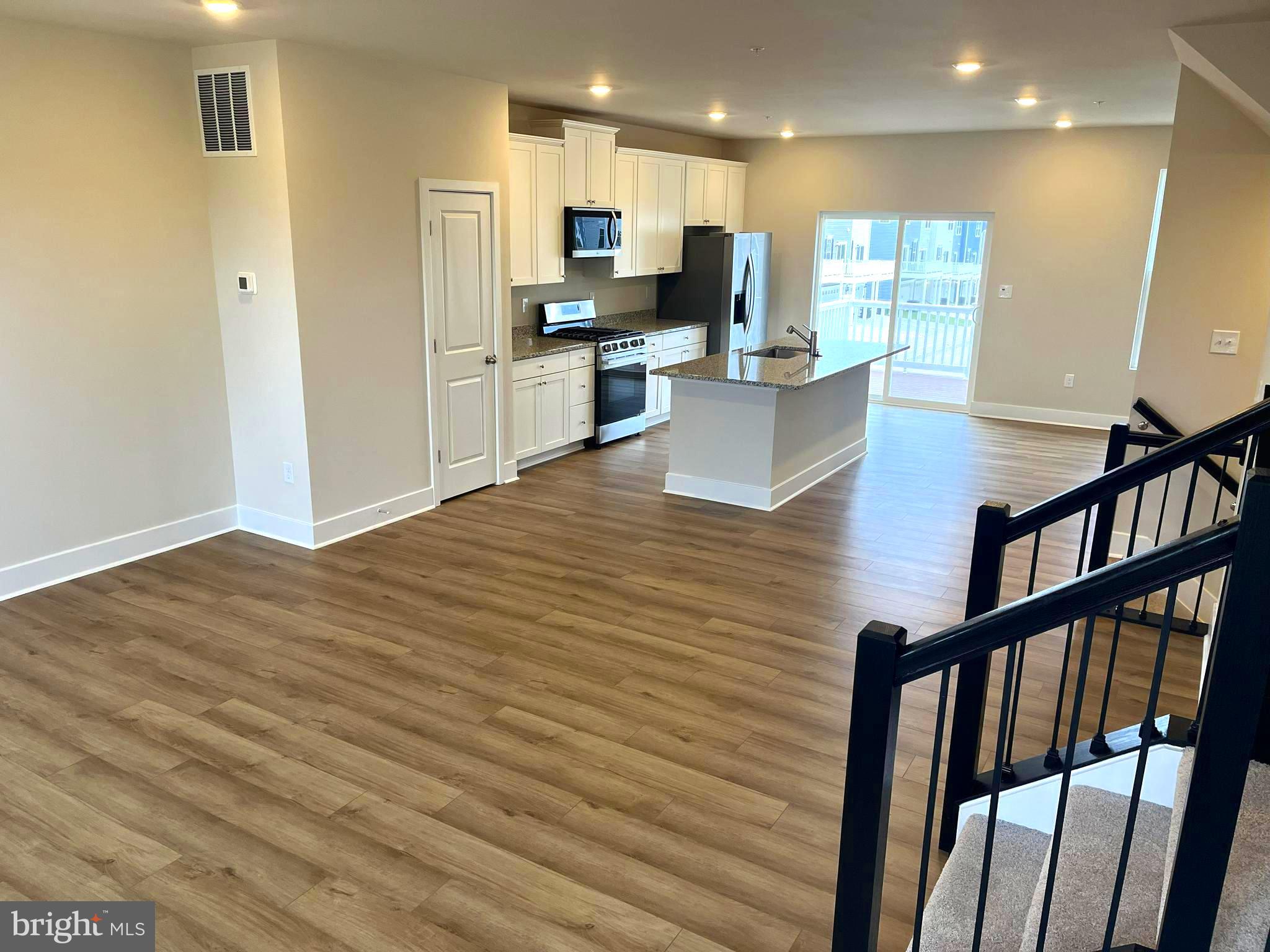 7618 Johnnycake Road Windsor Mill, MD 21244 - Photo 13 of 45 a view of a kitchen with kitchen island wooden floors appliances and furniture