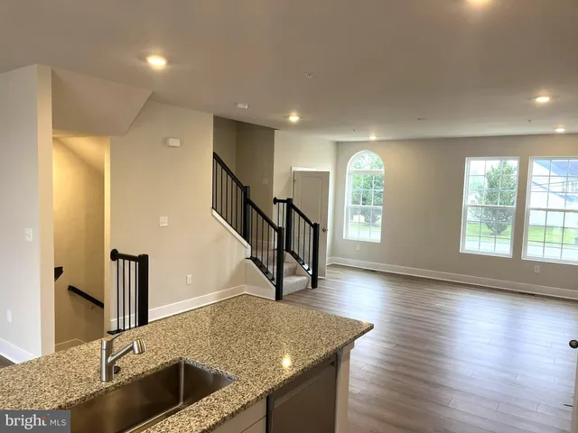 a kitchen with sink window and wooden floor