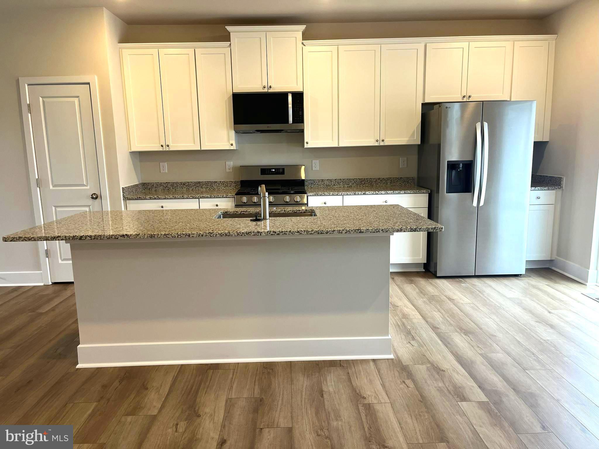 7618 Johnnycake Road Windsor Mill, MD 21244 - Photo 7 of 45 a kitchen with stainless steel appliances granite countertop a refrigerator a stove a sink and a granite counter tops with a window