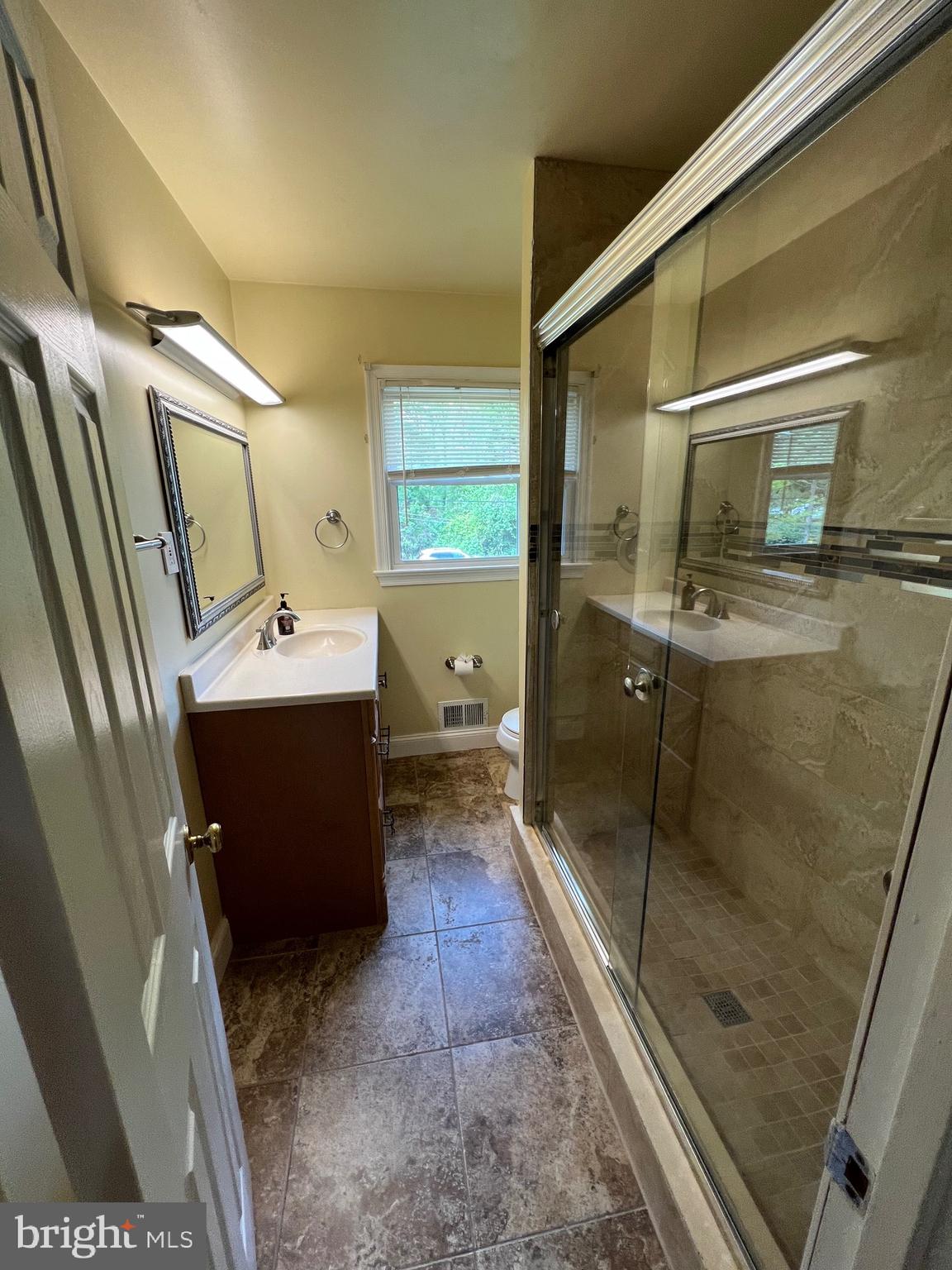 6825 Ridgeway Drive Springfield, VA 22150 - Photo 32 of 33 a bathroom with a sink a mirror and a shower