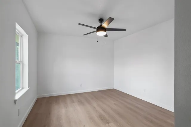 wooden floor in an empty room with a window