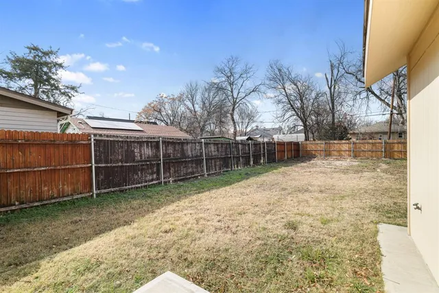 a view of backyard with wooden fence