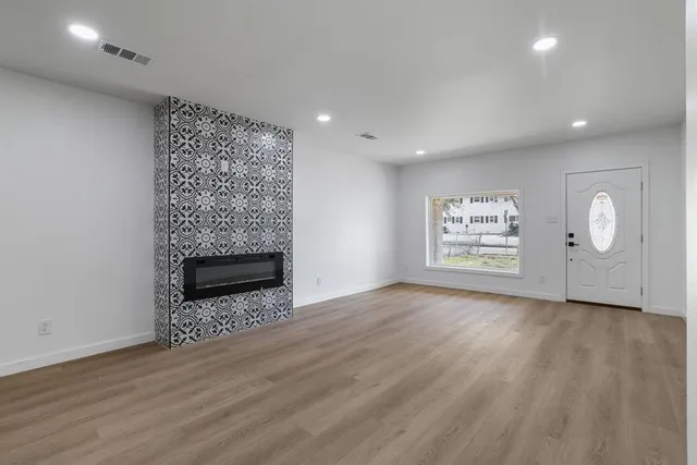 an empty room with wooden floor painted walls and a fireplace