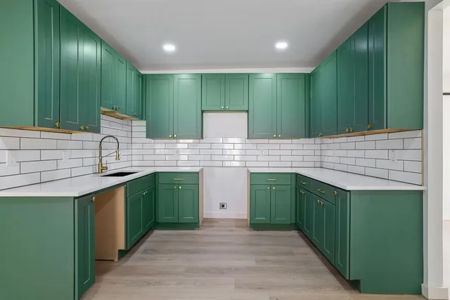 a kitchen with kitchen island a sink stainless steel appliances and cabinets