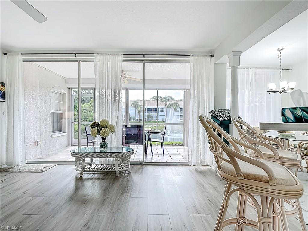 6834 Lantana Bridge Road, Unit 102 Naples, FL 34109 - Photo 15 of 45 a living room with furniture and a wooden floor