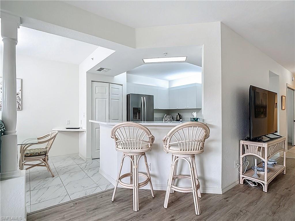 6834 Lantana Bridge Road, Unit 102 Naples, FL 34109 - Photo 16 of 45 a room with furniture and wooden floor