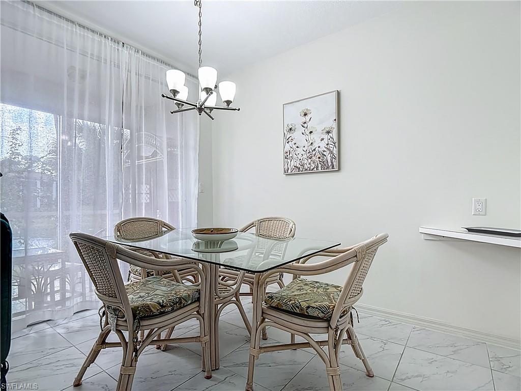 6834 Lantana Bridge Road, Unit 102 Naples, FL 34109 - Photo 17 of 45 a view of a dining room with furniture and a chandelier