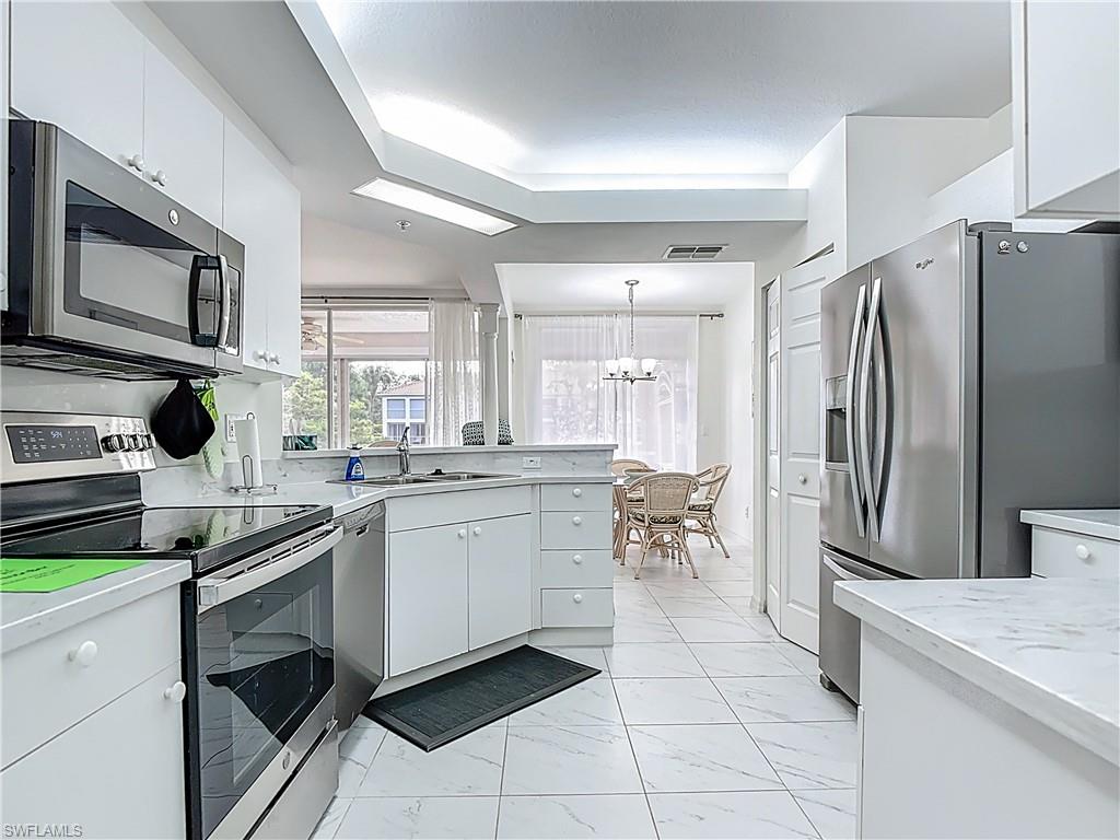 6834 Lantana Bridge Road, Unit 102 Naples, FL 34109 - Photo 20 of 45 a kitchen with a sink and refrigerator