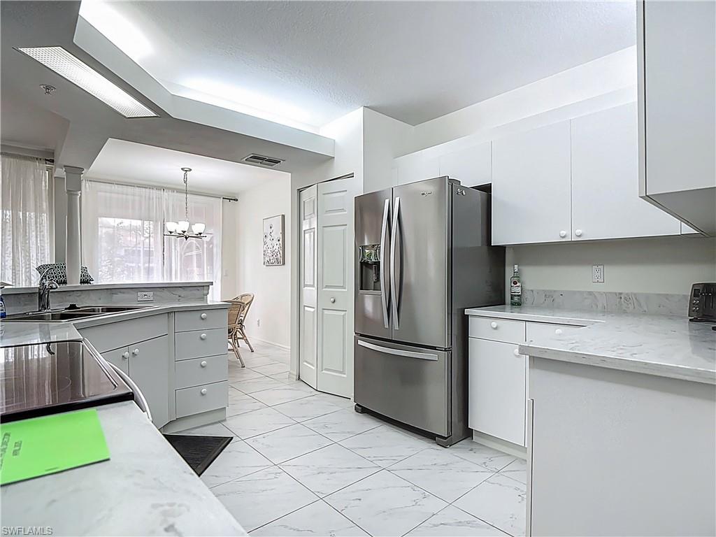 6834 Lantana Bridge Road, Unit 102 Naples, FL 34109 - Photo 21 of 45 a kitchen with a sink appliances and cabinets