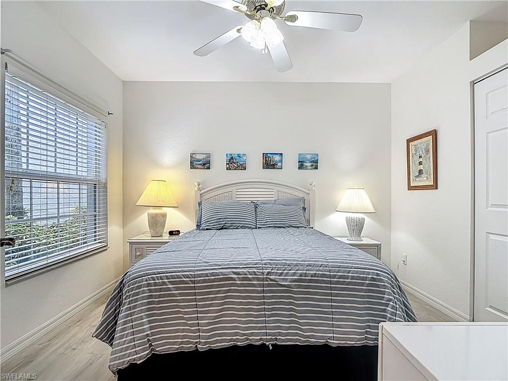6834 Lantana Bridge Road, Unit 102 Naples, FL 34109 - Photo 23 of 45 a bedroom with a bed and a night stand