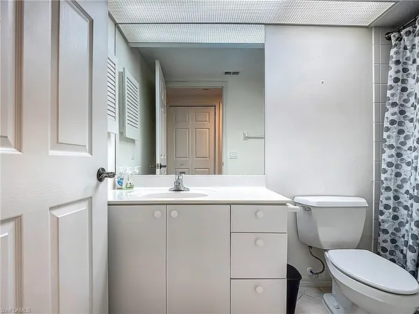 a bedroom with a bed a window and a chandelier