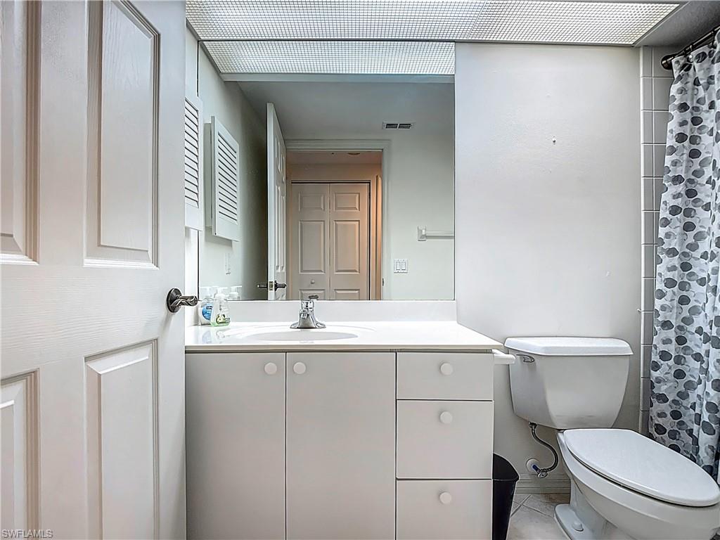 6834 Lantana Bridge Road, Unit 102 Naples, FL 34109 - Photo 25 of 45 a bathroom with a toilet a sink and mirror