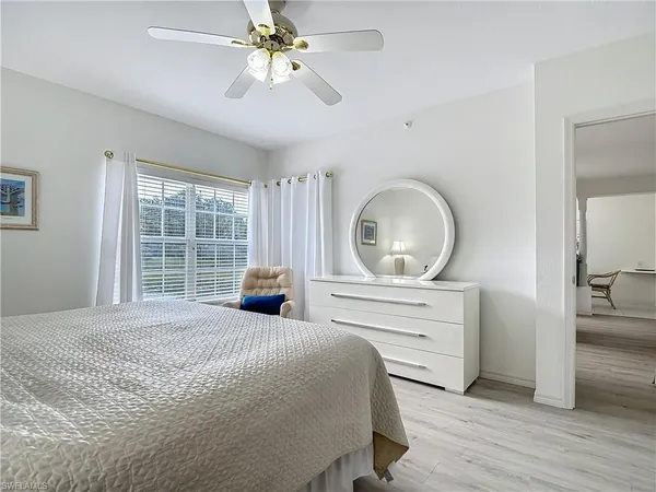 a spacious bedroom with a bed a couch and a large window
