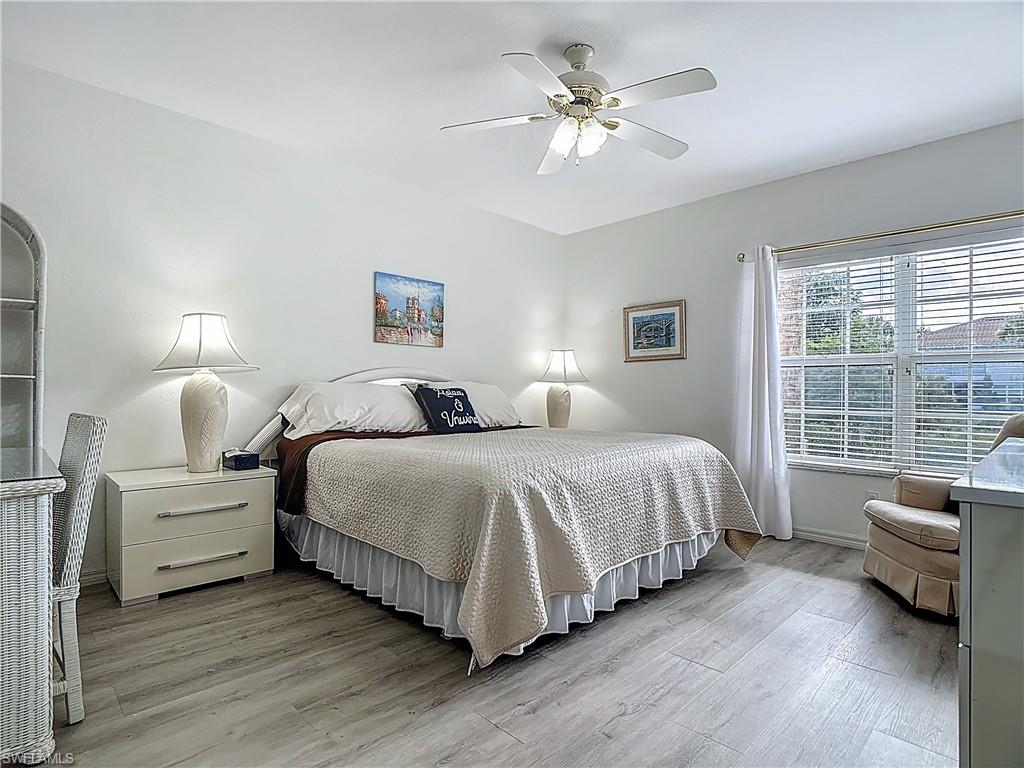 6834 Lantana Bridge Road, Unit 102 Naples, FL 34109 - Photo 27 of 45 a spacious bedroom with a bed a couch and a large window