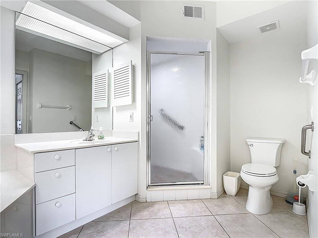 6834 Lantana Bridge Road, Unit 102 Naples, FL 34109 - Photo 29 of 45 a bathroom with a toilet sink and a mirror