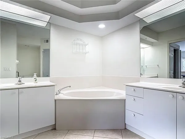 a bathroom with a tub sink and mirror