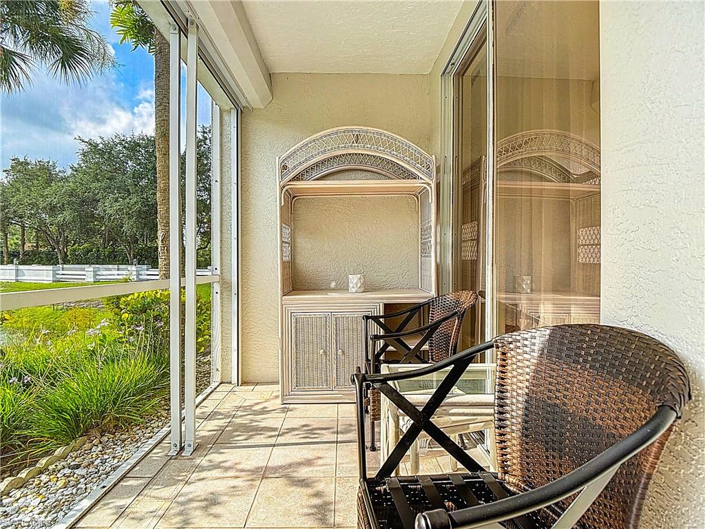 6834 Lantana Bridge Road, Unit 102 Naples, FL 34109 - Photo 42 of 45 a view of a balcony with table and chairs