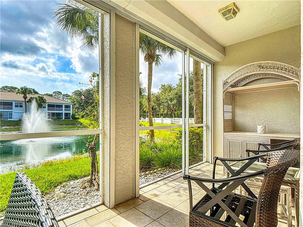 6834 Lantana Bridge Road, Unit 102 Naples, FL 34109 - Photo 43 of 45 a view of a swimming pool with lawn chairs and floor to ceiling window