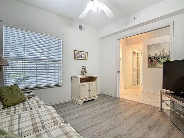 a living room with furniture flat screen tv and large window