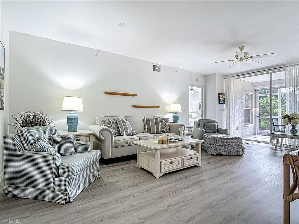 6834 Lantana Bridge Road, Unit 102 Naples, FL 34109 - Photo 9 of 45 a living room with furniture and a large window