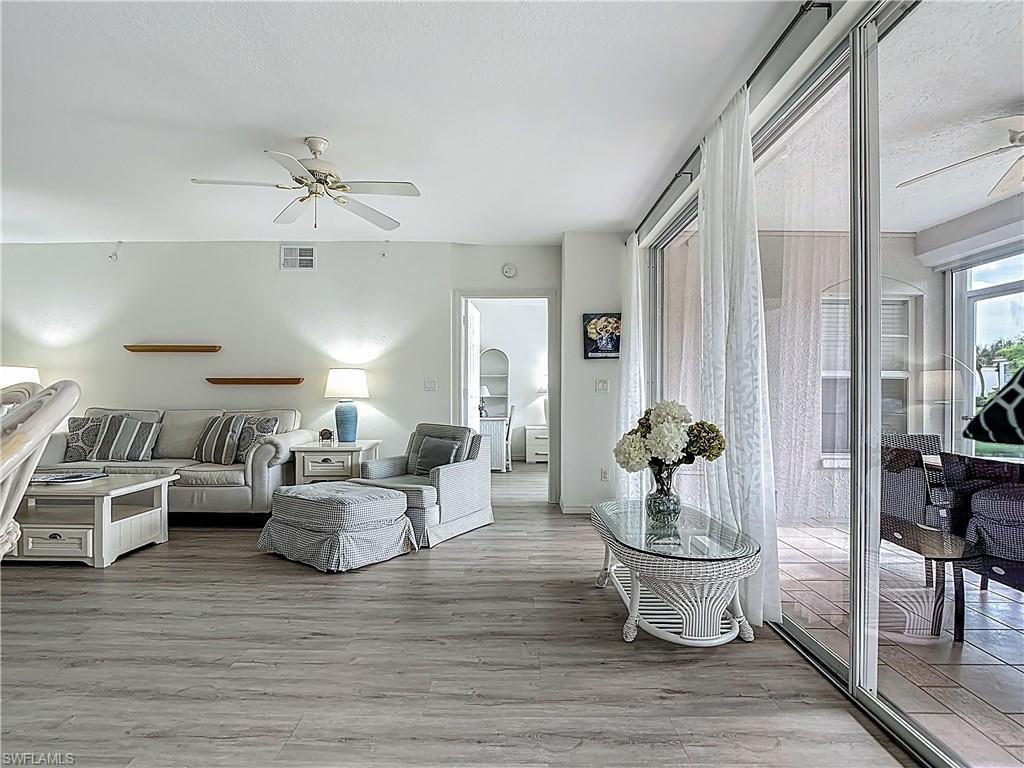 6834 Lantana Bridge Road, Unit 102 Naples, FL 34109 - Photo 10 of 45 a living room with furniture and wooden floor