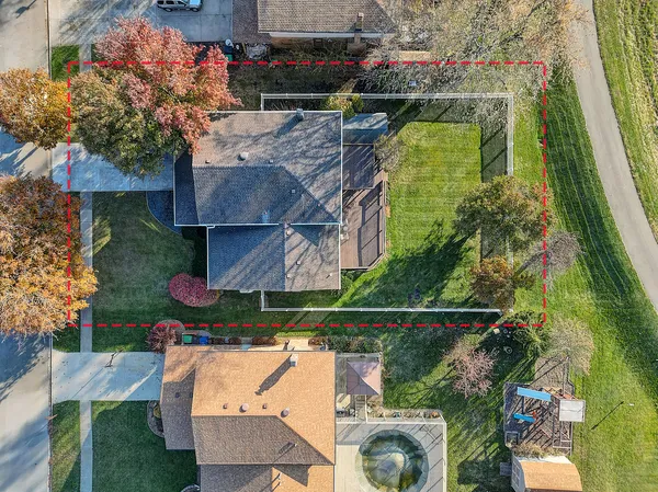 an aerial view of a house with a yard and a large pool
