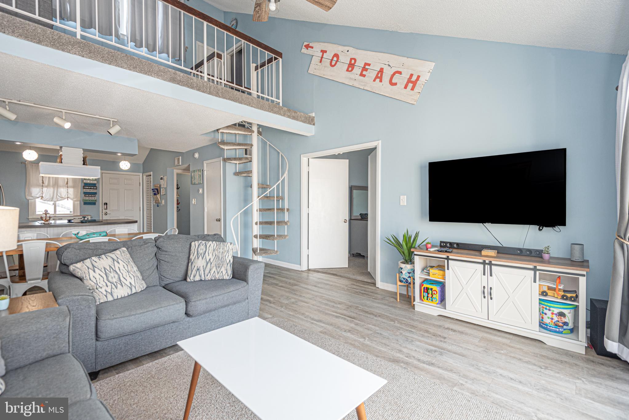9203 Rusty Anchor Road, Unit A5 Ocean City, MD 21842 - Photo 16 of 60 a living room with furniture and a flat screen tv