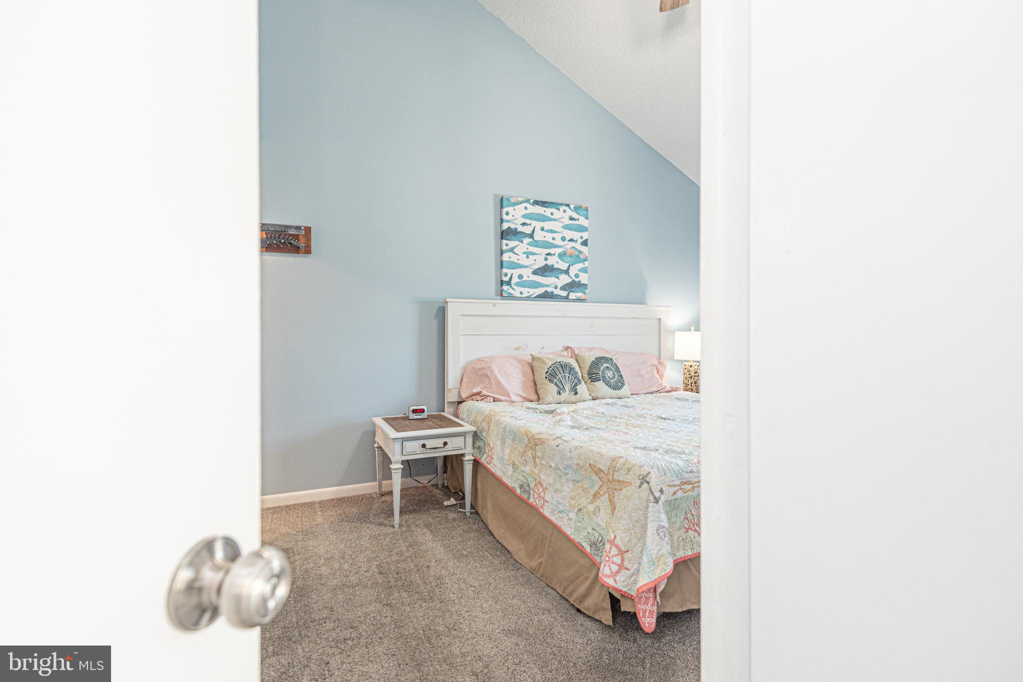 9203 Rusty Anchor Road, Unit A5 Ocean City, MD 21842 - Photo 17 of 60 a bedroom with a bed and a wall painting