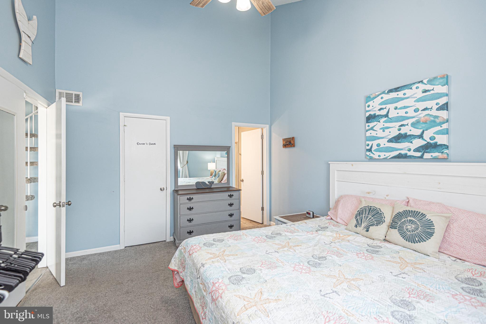 9203 Rusty Anchor Road, Unit A5 Ocean City, MD 21842 - Photo 19 of 60 a bedroom with a bed and a chandelier