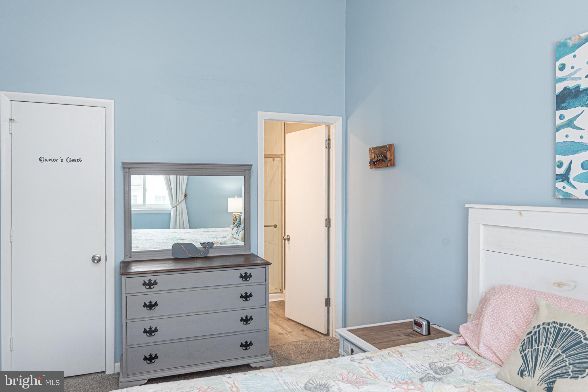9203 Rusty Anchor Road, Unit A5 Ocean City, MD 21842 - Photo 20 of 60 a bedroom with a bed and wooden floor