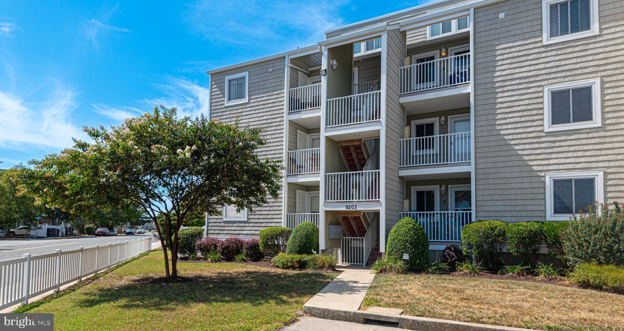 9203 Rusty Anchor Road, Unit A5 Ocean City, MD 21842 - Photo 2 of 60 a front view of a house with a yard