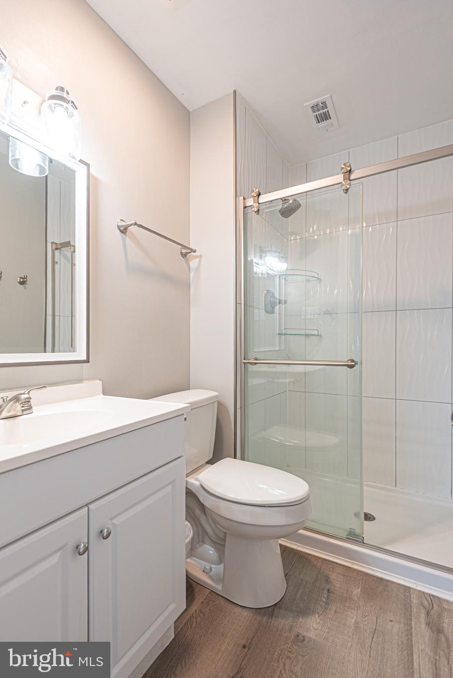 9203 Rusty Anchor Road, Unit A5 Ocean City, MD 21842 - Photo 22 of 60 a bathroom with a shower sink vanity mirror and toilet