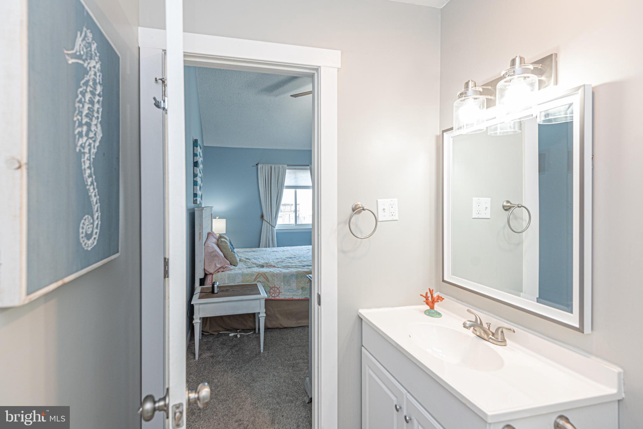 9203 Rusty Anchor Road, Unit A5 Ocean City, MD 21842 - Photo 23 of 60 a en suite bathroom with a sink mirror and a shower