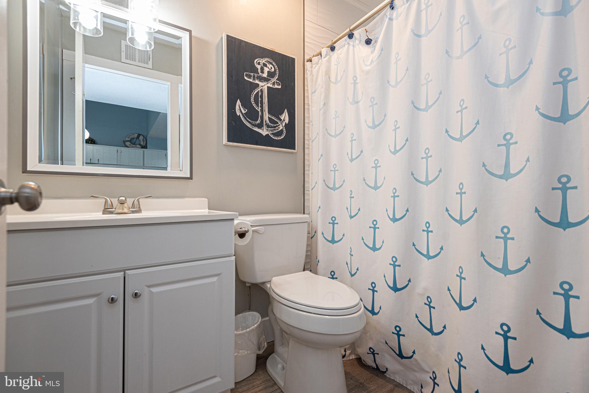 9203 Rusty Anchor Road, Unit A5 Ocean City, MD 21842 - Photo 38 of 60 a bathroom with a toilet sink and mirror