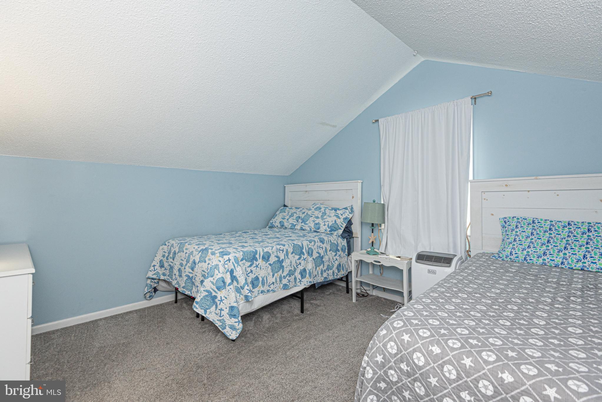 9203 Rusty Anchor Road, Unit A5 Ocean City, MD 21842 - Photo 46 of 60 a bedroom with a bed and a table