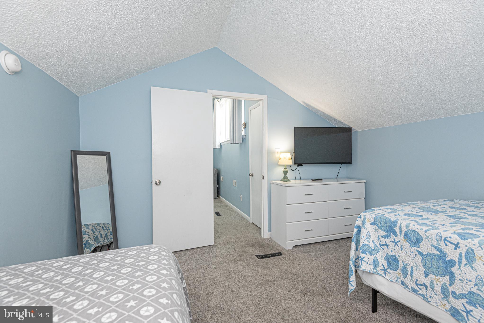 9203 Rusty Anchor Road, Unit A5 Ocean City, MD 21842 - Photo 47 of 60 a bedroom with a bed and flat screen tv