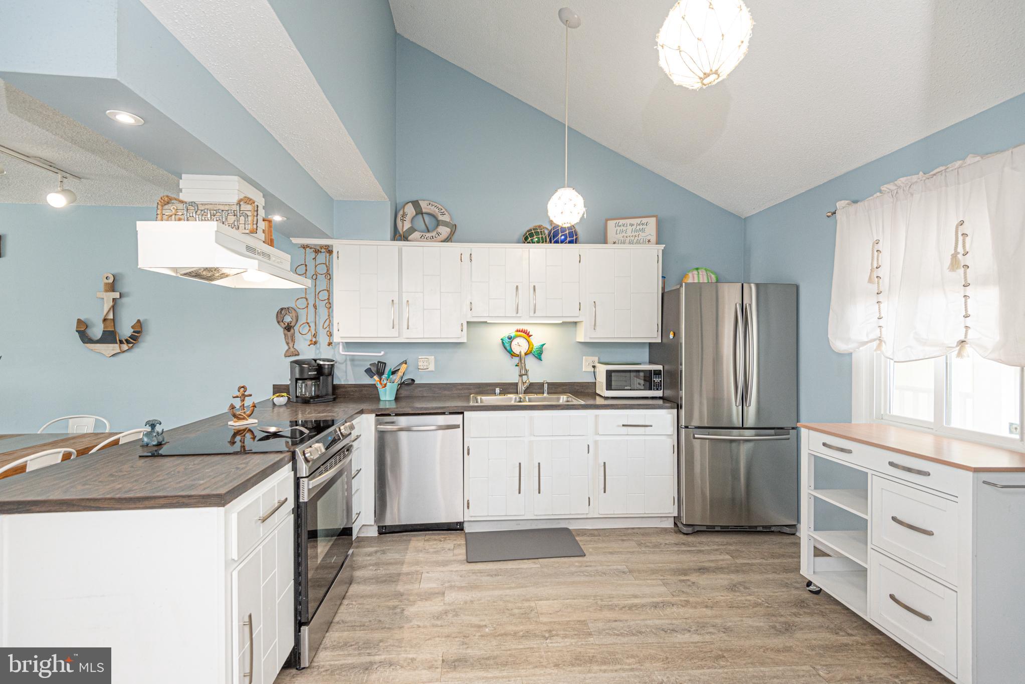 9203 Rusty Anchor Road, Unit A5 Ocean City, MD 21842 - Photo 7 of 60 a kitchen with granite countertop a sink stove refrigerator and cabinets