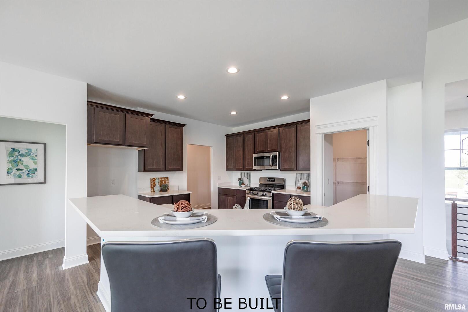 10 South 5th Street Eldridge, IA 52748 - Photo 7 of 29 a dining hall with stainless steel appliances granite countertop a sink a stove a dining table and chairs with wooden floor