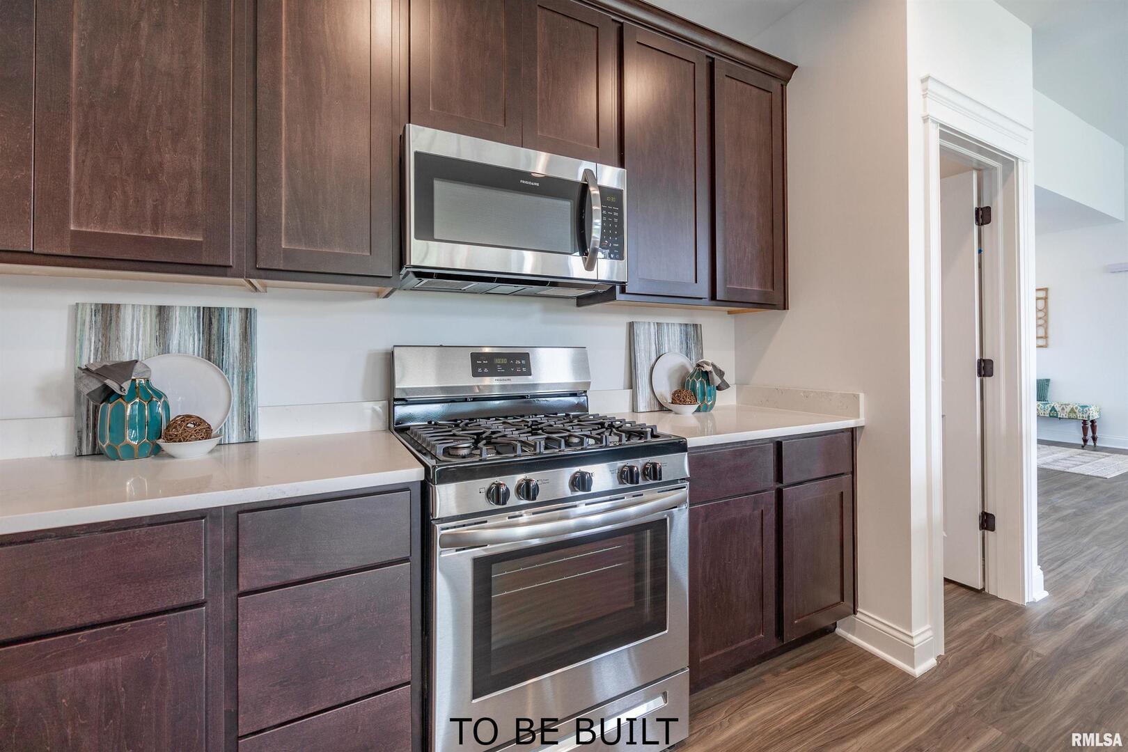 10 South 5th Street Eldridge, IA 52748 - Photo 10 of 29 a kitchen with stainless steel appliances granite countertop a stove a microwave and cabinets