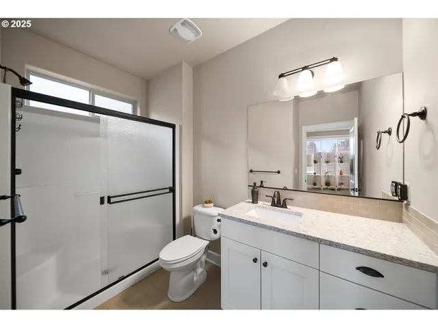 a bathroom with a sink toilet a mirror and shower