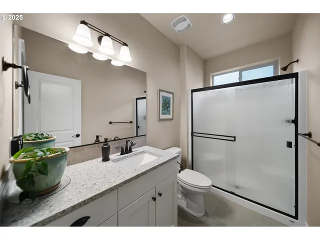 a bathroom with a double vanity sink mirror and toilet