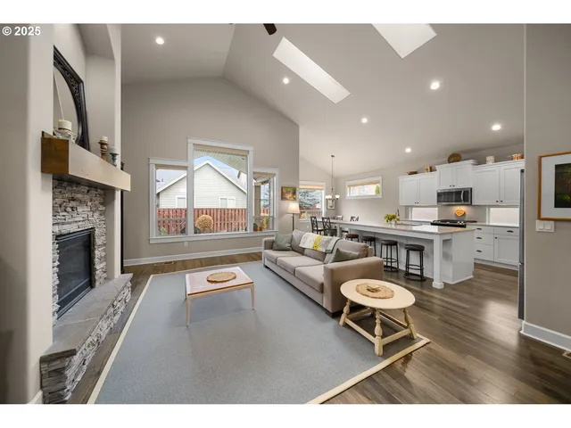 a living room with stainless steel appliances kitchen island furniture and a fireplace