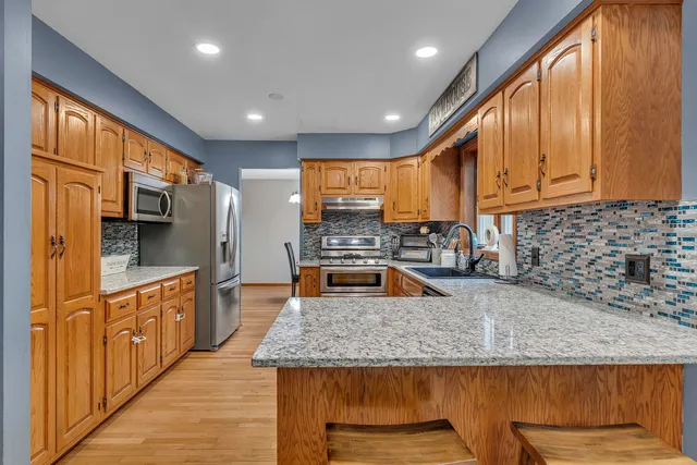 a kitchen with stainless steel appliances granite countertop a sink refrigerator and microwave