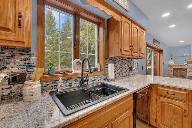 a kitchen with stainless steel appliances granite countertop a sink stove and cabinets